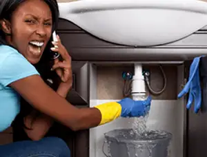 Emergency plumbing repair for a leaking sink drain under a bathroom vanity in Kansas City, KS