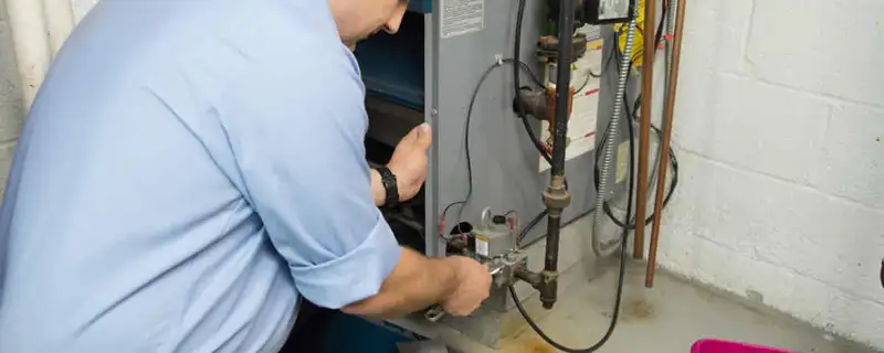 Furnace repair technician inspecting and servicing a home heating system in Kansas City, KS
