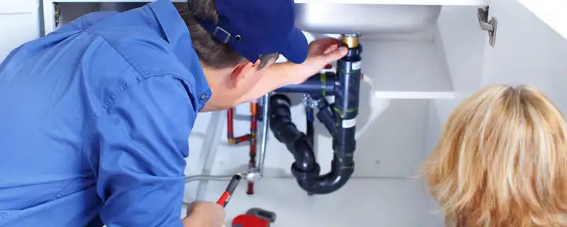 Plumber repairing under-sink drain pipes and fittings in Kansas City, KS